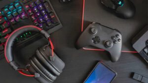 Mesa com fone de ouvido, teclado, mouse, celular e controle de videogame